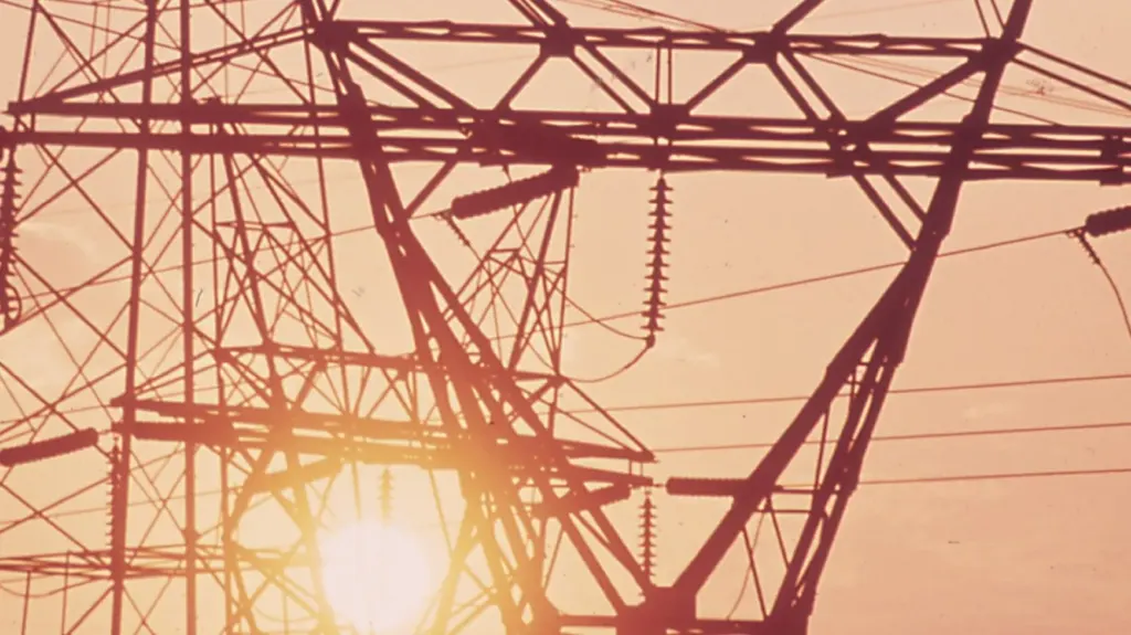 Transmission towers silhouetted against the sun near Houston