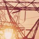 Transmission towers silhouetted against the sun near Houston